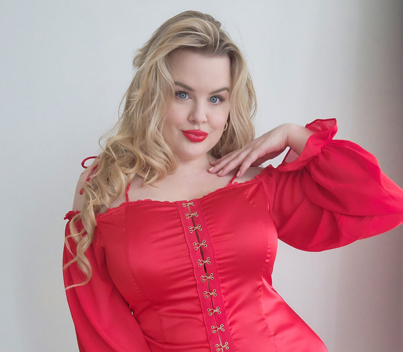 Lilli Luxe wearing a red off-the-shoulder dress